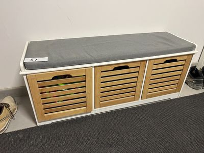 une photo d'un banc de rangement pour chaussures placé dans un coin de la pièce