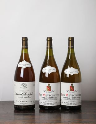 trois bouteilles de vin posées sur une table, l'une à côté de l'autre