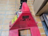 a red fire hydrant sitting on the floor next to a pile of wood