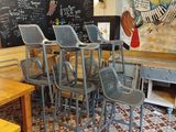 tables and chairs in a restaurant with a chalk board on the wall