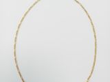 a gold chain necklace with a single link on a white background
