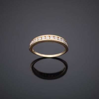 a yellow gold ring with diamonds on a black surface