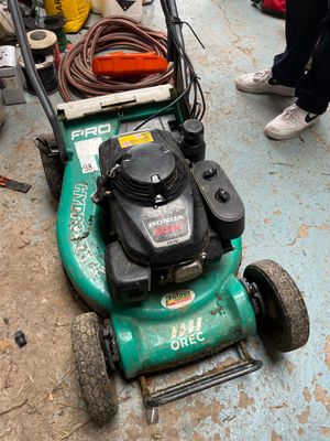 a green lawn mower that is sitting on the ground