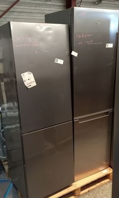 three stainless steel refrigerators are stacked on pallets in a warehouse