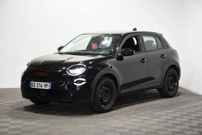 la petite voiture noire est garée dans une pièce au sol en damier