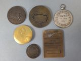 several coins and a medal are sitting on a table