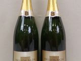 two bottles of champagne sitting next to each other on a table