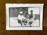 photographie en noir et blanc d'un groupe d'hommes assis autour d'une table