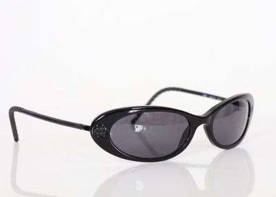 sunglasses on a white surface with a reflection of the lens