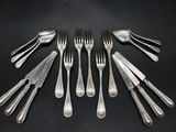 six forks and a knife are arranged in a circle on a black surface
