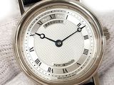 a silver watch with roman numerals on a black strap