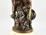 une image représentant une statue en bronze de deux hommes posée sur un socle en marbre