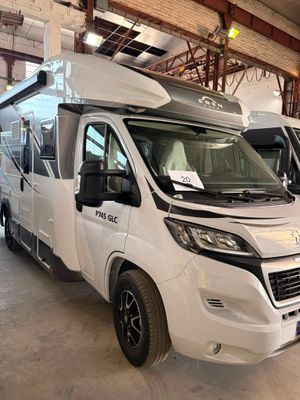 deux camping-cars blancs garés dans un garage
