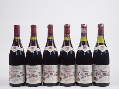 six bouteilles de vin alignées sur une surface blanche