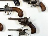 many old guns that are on a white surface