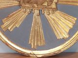a gold clock with a picture of a bird on it