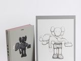 two books on a white surface with a drawing of a person