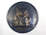 a coin with a statue on it on a white surface