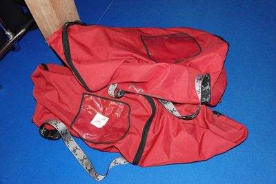 un sac rouge posé par terre à côté d'un sol bleu