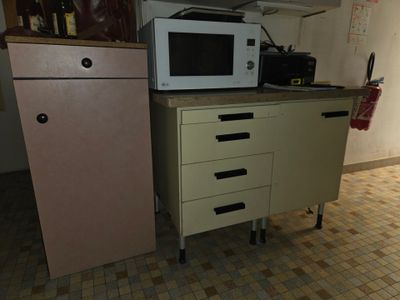 un micro-ondes posé sur un meuble, à côté d'un réfrigérateur