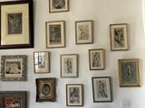 a wall of framed pictures on the wall of a living room