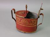 a red and gold teapot with a spoon in it