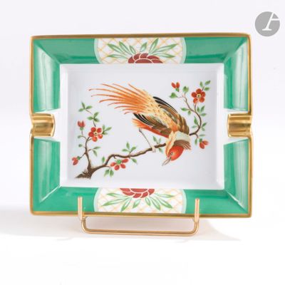 une assiette verte et dorée sur laquelle est représenté un oiseau
