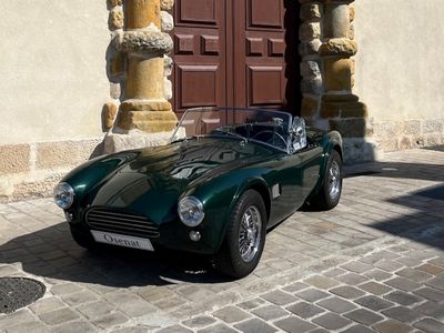 une voiture de sport verte garée devant un immeuble