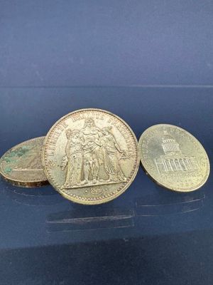 trois pièces de monnaie britanniques empilées les unes sur les autres sur une surface bleue