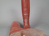 pair of brown boots with yellow soles on a gray surface