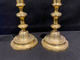 pair of antique brass candlesticks on a black background