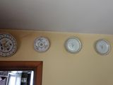 cinq assiettes accrochées au mur au-dessus d'un miroir