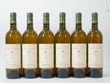 six bouteilles de vin sont alignées sur une surface blanche