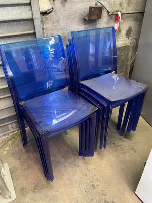 three blue plastic chairs sitting next to each other in a room
