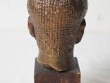 sculpture of a head on a wooden block on a white background
