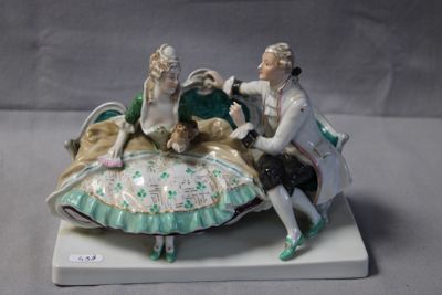 a figurine of a man and a woman sitting on a shell