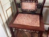a wooden chair that has a pink seat on it