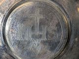 a silver plate with a cross and a heart on it