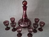 a wine decanter and six wine glasses on a table