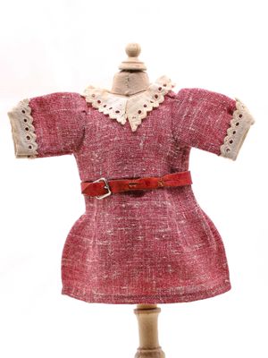 une robe posée sur un mannequin, avec une ceinture rouge