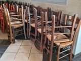 de nombreuses chaises en bois alignées les unes à côté des autres dans une pièce