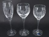 three clear wine glasses sitting next to each other on a black surface