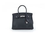 un sac à main en cuir noir sur fond blanc