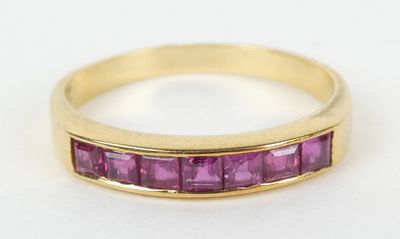 Gros plan sur une bague en or ornée de pierres roses