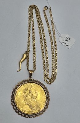 un gros plan d'un collier composé d'une pièce d'or suspendue à une chaîne
