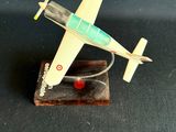 une petite maquette d'avion posée sur un socle en bois