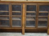 une armoire en bois surmontée de portes vitrées