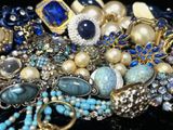 un tas de bijoux posés sur une table, sur fond noir