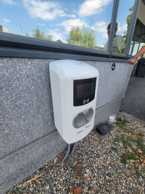 une personne se tenant à l'extérieur d'un bâtiment, munie d'une télécommande