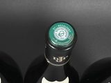 four bottles of wine are lined up in a row on a table